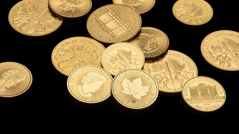 Plusieurs pièces d'or de différents types disposées sur un fond noir.